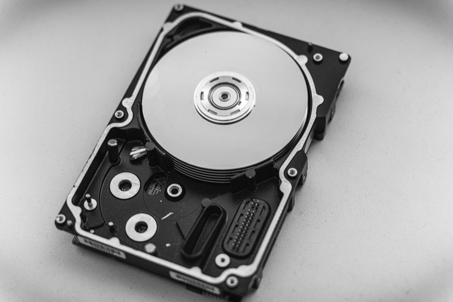 An opened hard drive showing its platter and read arm